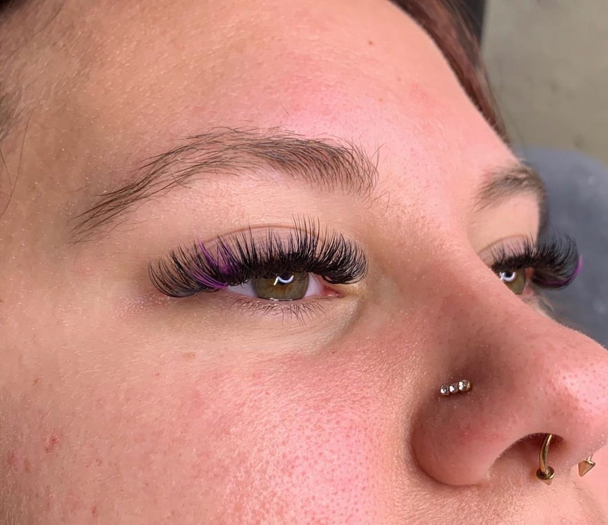 Close-up of a hybrid lash extension set with a purple accent lash, applied at GreenRoom Salon & Spa in Greencastle, Indiana