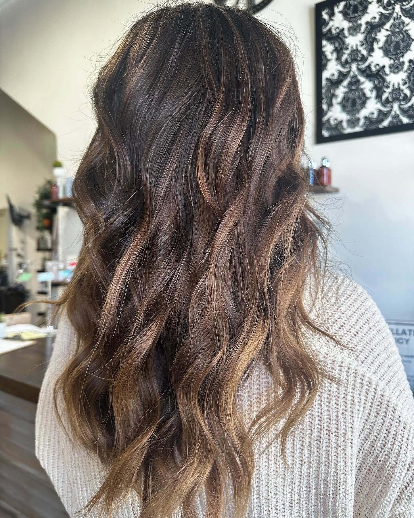 Warm brunette balayage melting into caramel ends on long wavy hair, hand-painted at GreenRoom Salon & Spa in Greencastle, Indiana